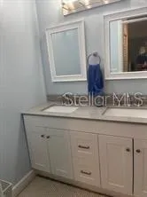 a bathroom with a sink and two mirror