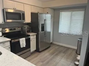 a kitchen with stainless steel appliances a stove microwave and refrigerator
