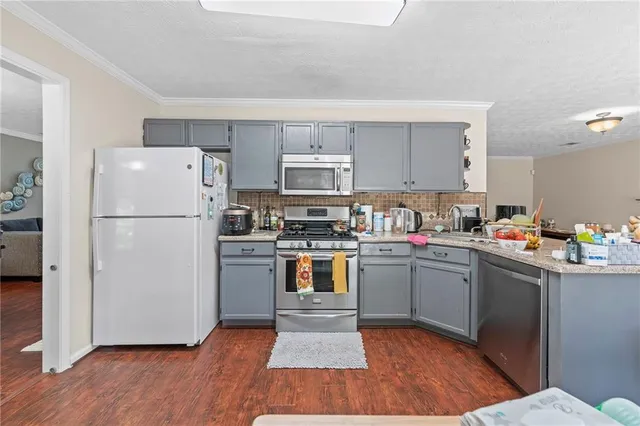 a kitchen with a refrigerator and a stove top oven