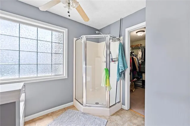 a bedroom with a bed and a ceiling fan