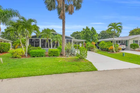 a view of a garden with a tree in front of the house