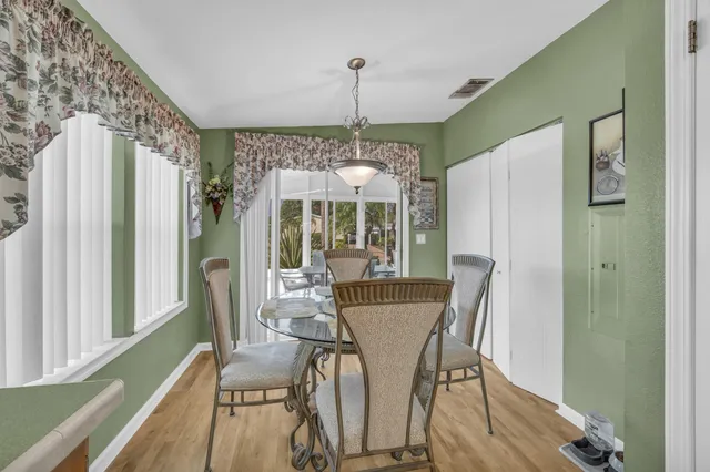 a dining room with furniture a chandelier and wooden floor
