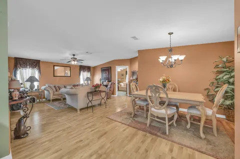 a living room with furniture dining table and a chandelier