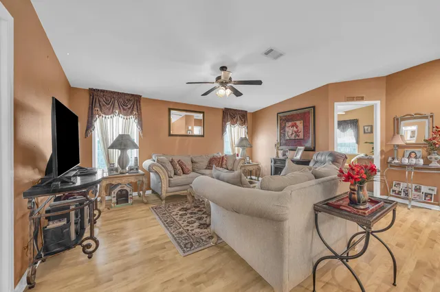 a living room with furniture a flat screen tv and a window