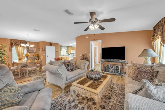 a living room with furniture a flat screen tv and a large window
