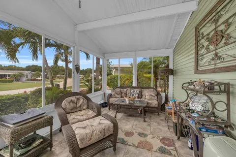 a living room with furniture and a floor to ceiling window