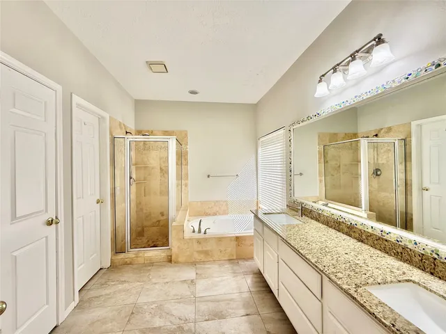 a large bathroom with a granite countertop tub sink and shower