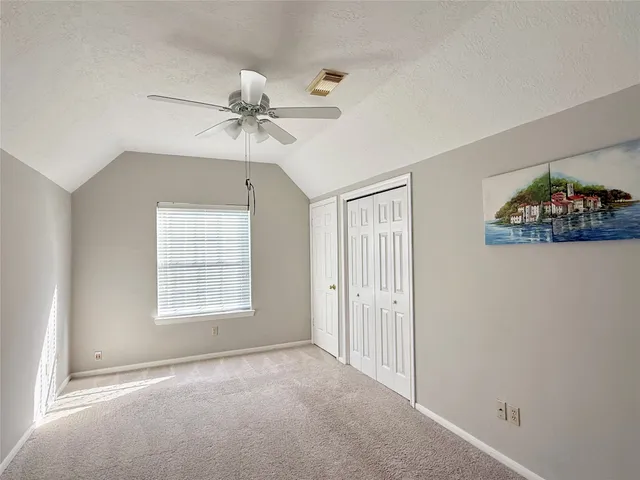 an empty room with windows and fan