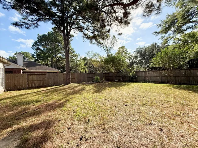 a view of backyard with wooden fence