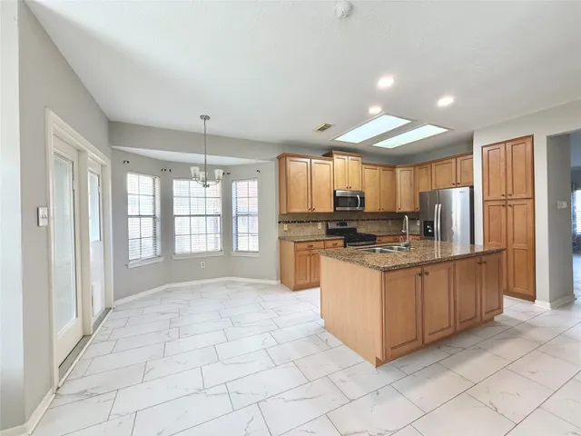 a kitchen with stainless steel appliances granite countertop a refrigerator and a sink