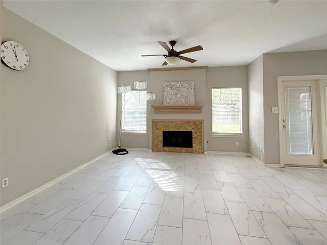 an empty room with windows and fireplace
