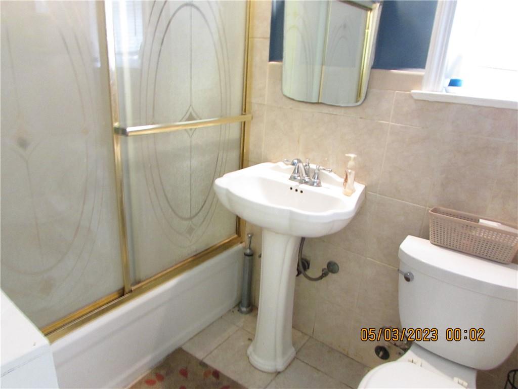 2806 Sexton Place Bronx, NY 10469 - Photo 11 of 18 a bathroom with a sink a toilet and mirror