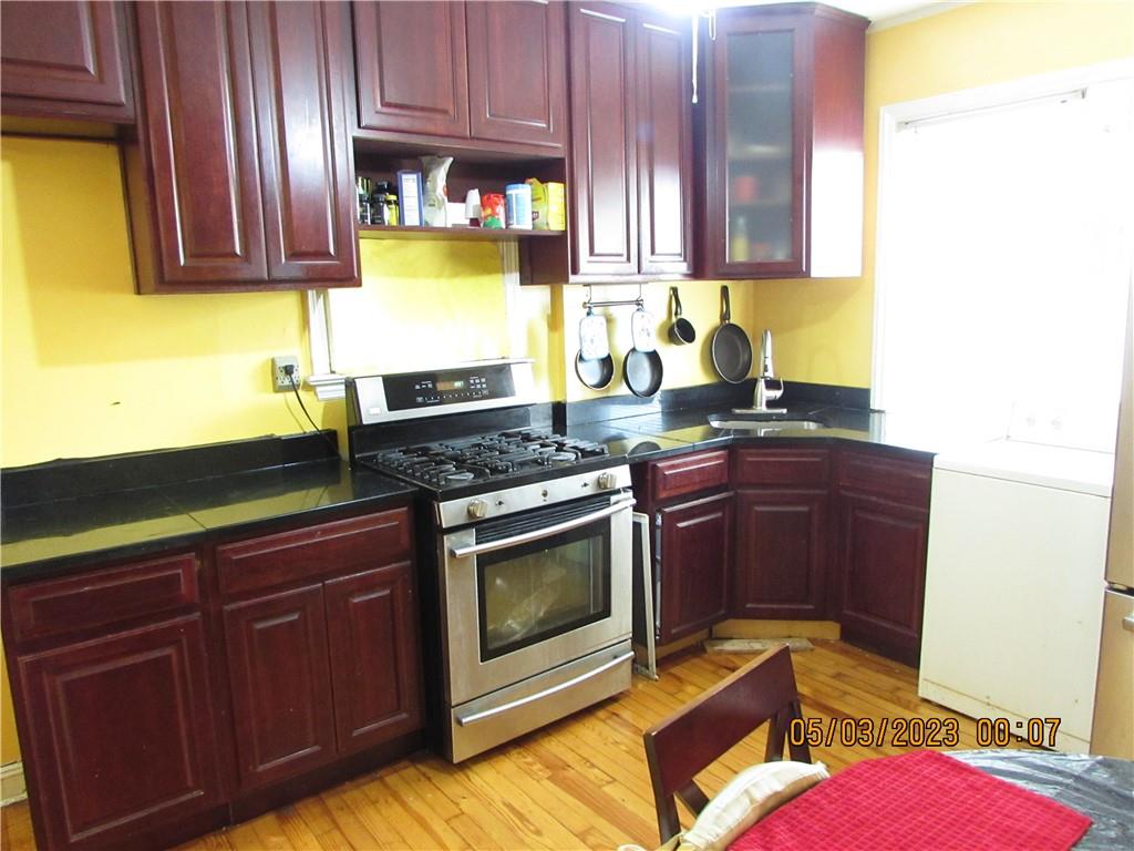 2806 Sexton Place Bronx, NY 10469 - Photo 9 of 18 a kitchen with granite countertop wood cabinets stainless steel appliances and a sink