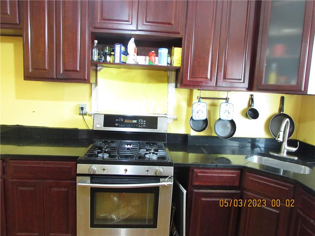 2806 Sexton Place Bronx, NY 10469 - Photo 10 of 18 a kitchen with stainless steel appliances granite countertop a stove and a cabinets
