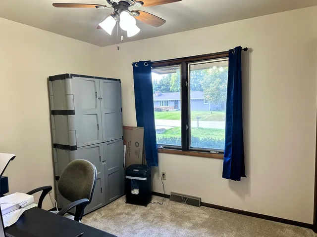 a view of a workspace with furniture and a window