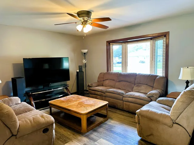 a living room with furniture a flat screen tv and a large window