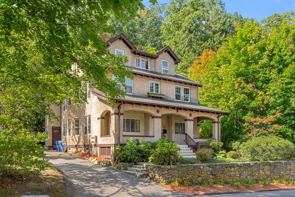 a front view of a house with a yard and potted plants