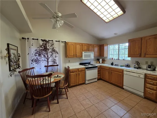 a kitchen with stainless steel appliances granite countertop a sink dishwasher a dining table and chairs with wooden floor