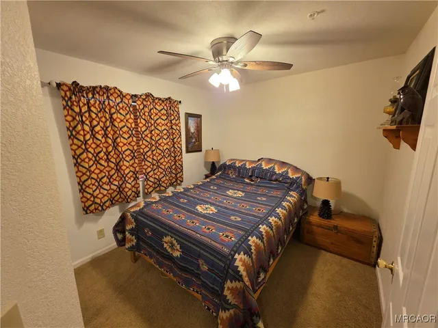 a bedroom with a bed and ceiling fan