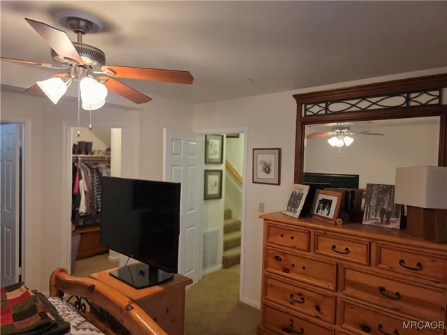 a bedroom with a bed and a flat tv screen on a dresser