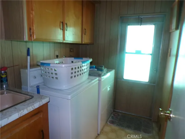 a room with water heater and a wooden cabinets