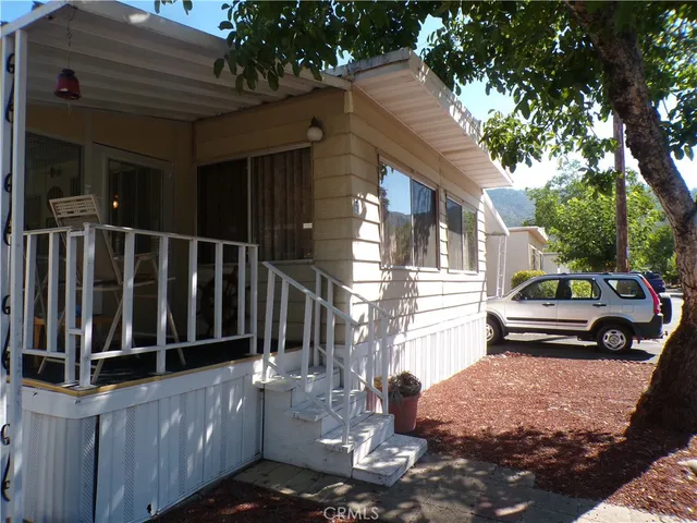 a view of a house with a small yard and wooden fence