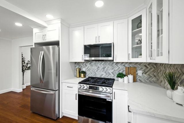 a kitchen with stainless steel appliances a stove a microwave and a refrigerator