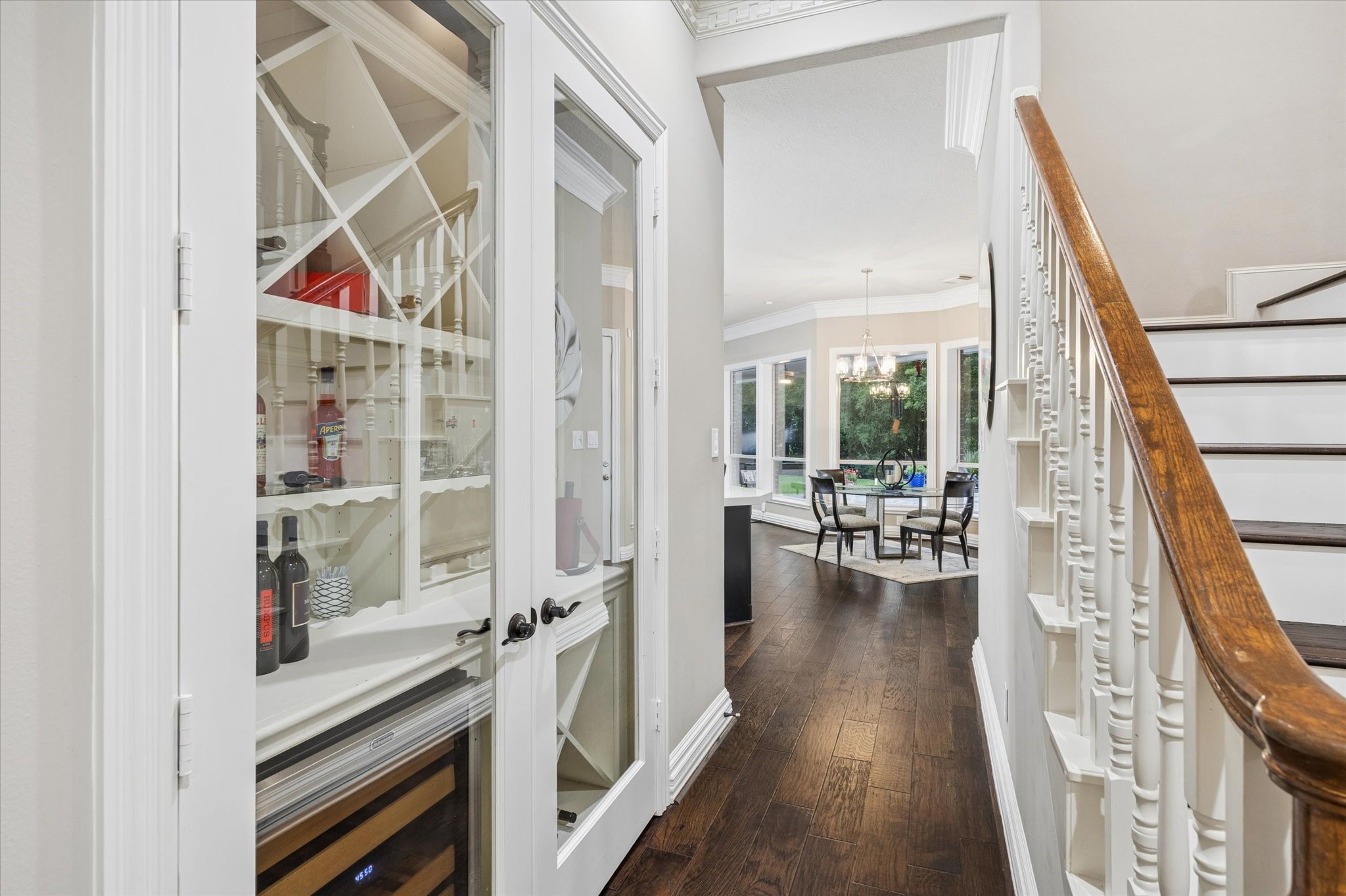 35 North Regent Oak Spring, TX 77381 - Photo 6 of 43 Beautifully integrated into the home's interior, this custom wine alcove adds a touch of sophistication and timeless appeal. Featuring glass doors, built-in wine storage, and elegant display shelving, it provides a stylish space to showcase a curated collection while reflecting the thoughtful design and attention to detail found throughout the residence.