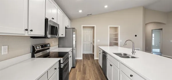 a kitchen with stainless steel appliances granite countertop a sink a stove and a refrigerator
