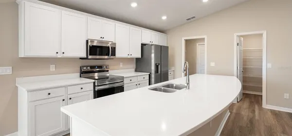 a kitchen with stainless steel appliances white cabinets and wooden floors