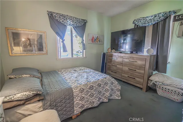 a bedroom with a bed and a television