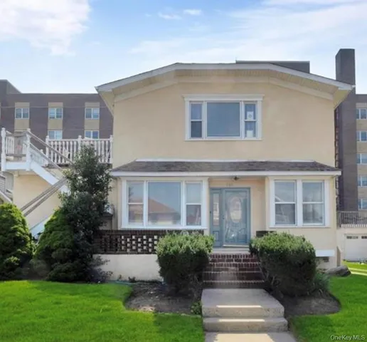 a front view of a house with garden and porch