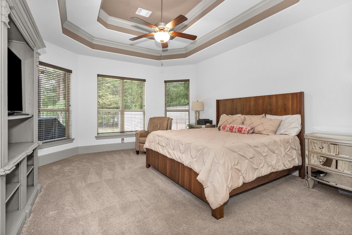 106 Cliftons Curve Way Montgomery, TX 77316 - Photo 25 of 47 Discover your serene retreat in this spacious primary suite, featuring elegant tray ceilings, abundant natural light, and a cozy, inviting atmosphere perfect for relaxation.