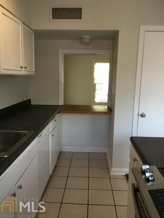 a kitchen with a sink a stove and cabinets