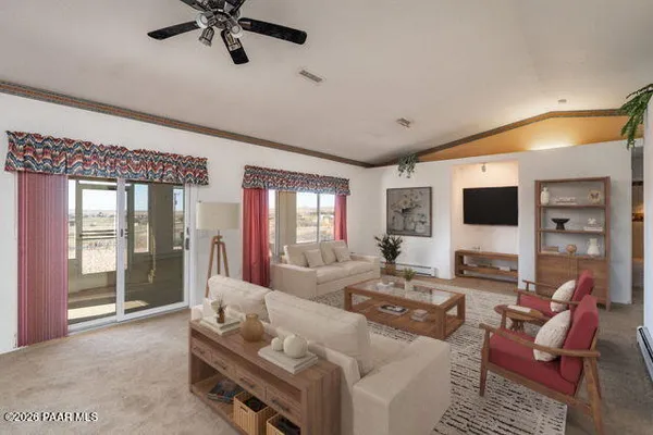 a view of a livingroom with a chandelier fan and wooden floor