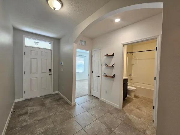 a kitchen with granite countertop wooden cabinets a refrigerator and a sink