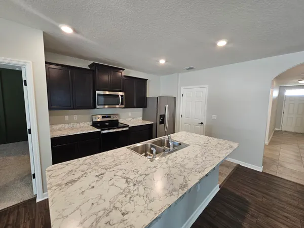 a kitchen with stainless steel appliances granite countertop a sink stove and refrigerator