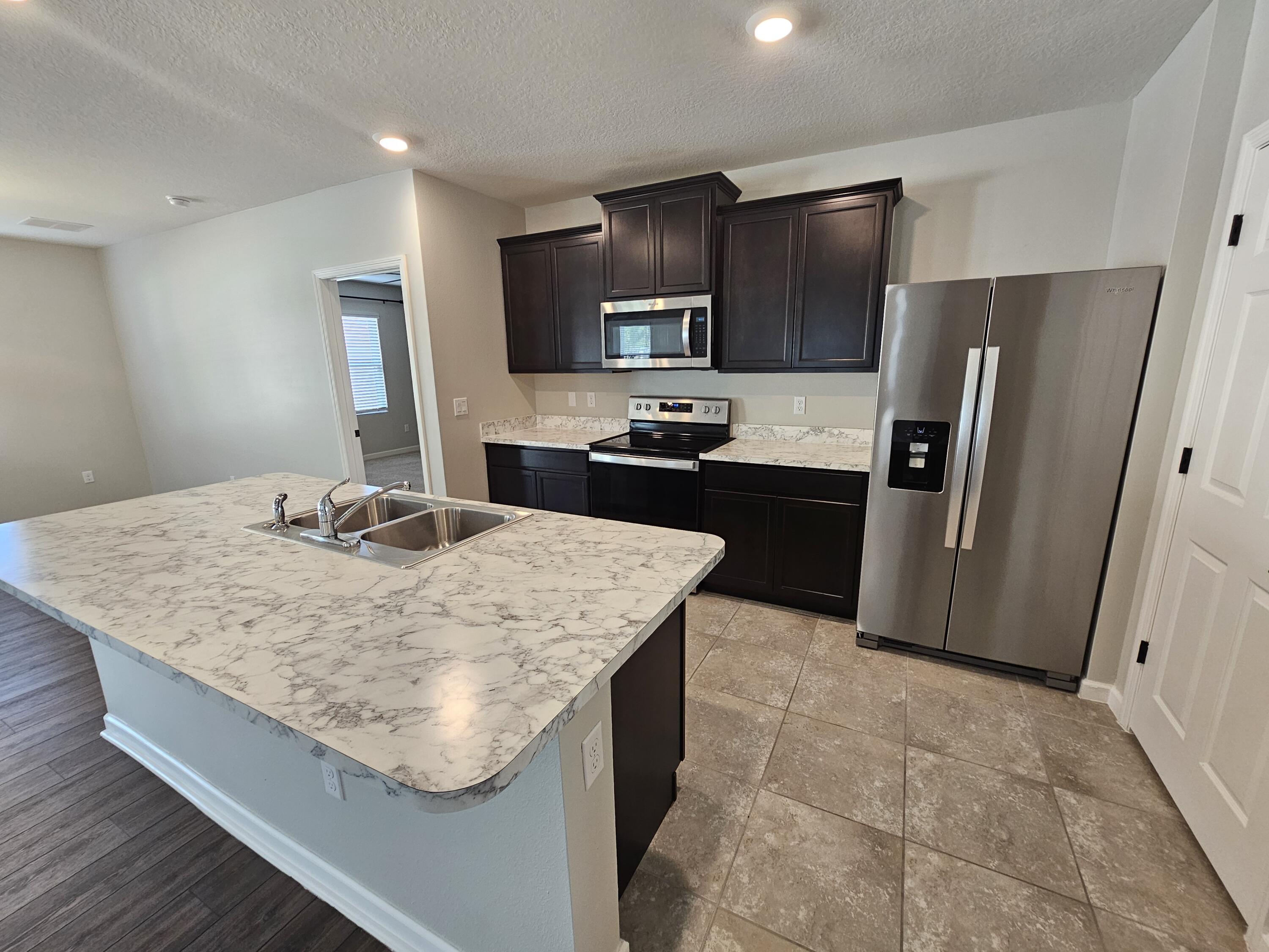 480 Sorrento Drive Cocoa, FL 32922 - Photo 5 of 24 a kitchen with stainless steel appliances granite countertop a sink stove and refrigerator