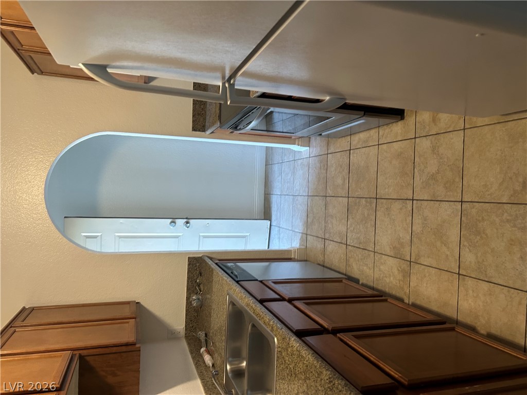 1852 North Decatur Boulevard, Unit 103 Las Vegas, NV 89108 - Photo 3 of 10 Functional kitchen with ample cabinet space, durable countertops, and an archway leading to additional living areas.