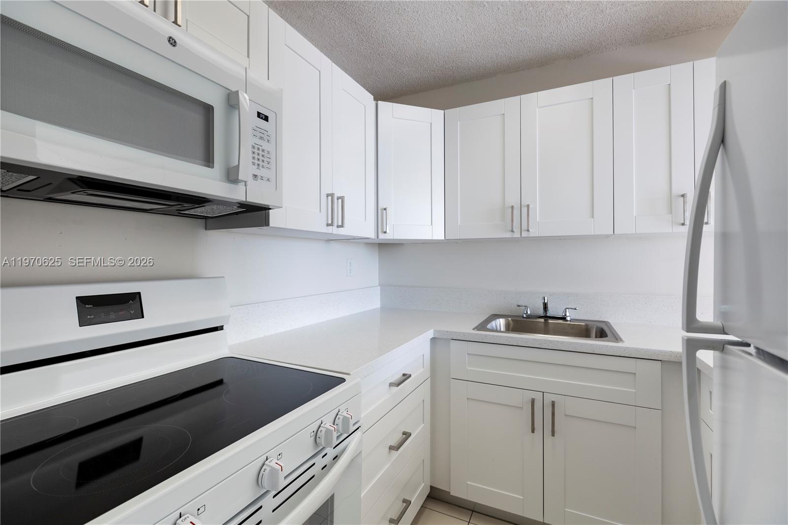 191 Northwest 97th Avenue, Unit 421 Miami, FL 33174 - Photo 3 of 15 a kitchen with white cabinets and white appliances