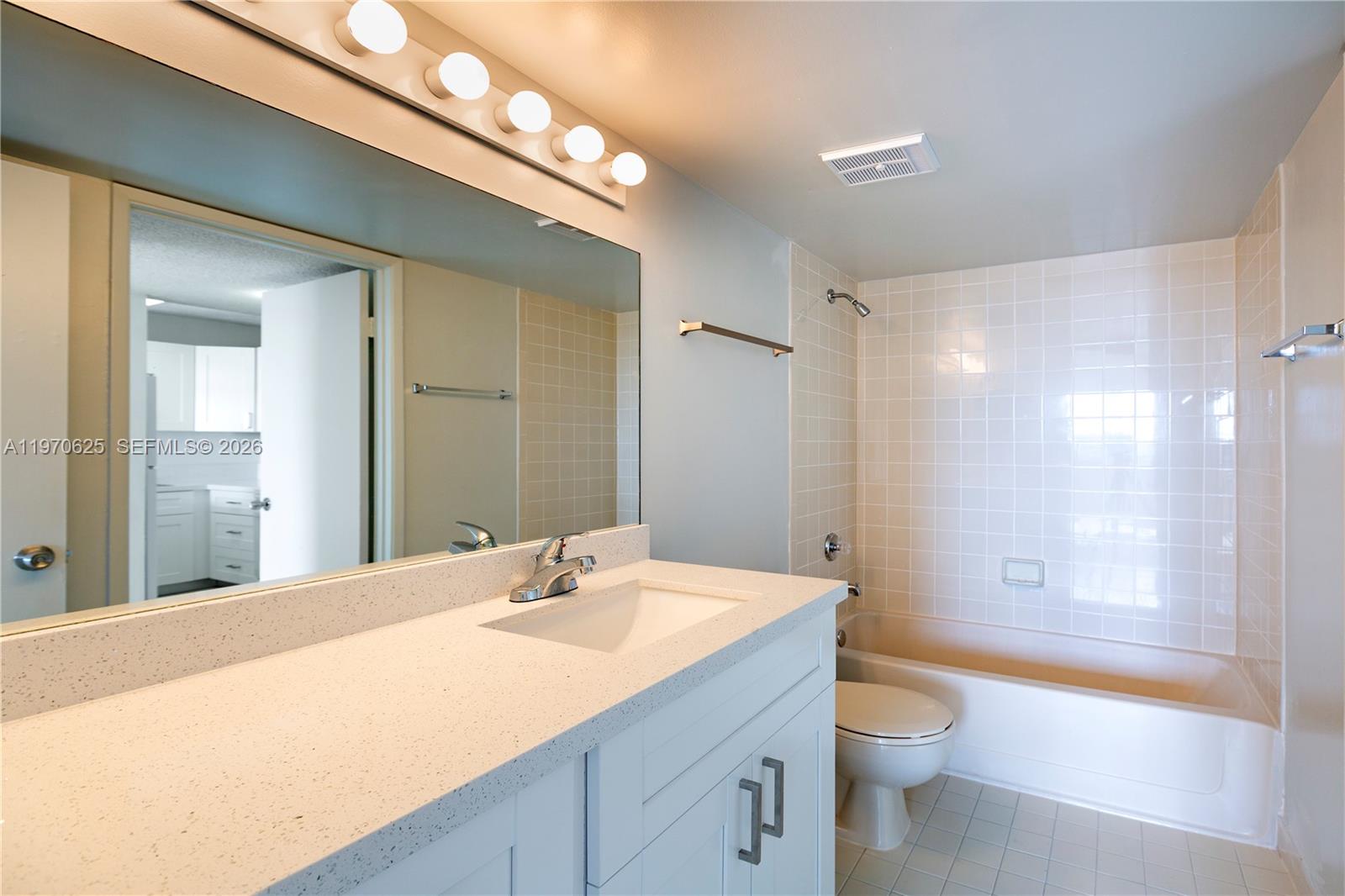 191 Northwest 97th Avenue, Unit 421 Miami, FL 33174 - Photo 9 of 15 a bathroom with a granite countertop sink a toilet and shower