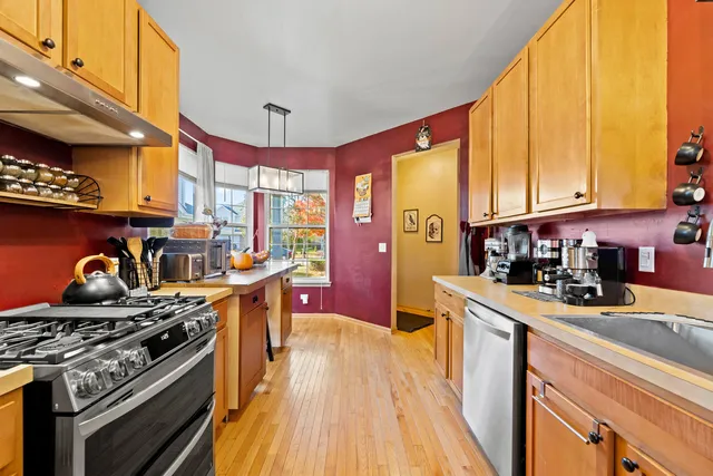 a kitchen with stainless steel appliances granite countertop a stove a sink and a microwave