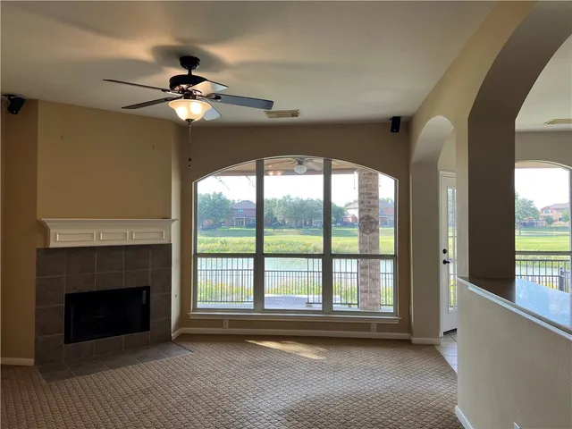 a view of livingroom with window fireplace and a ceiling fan