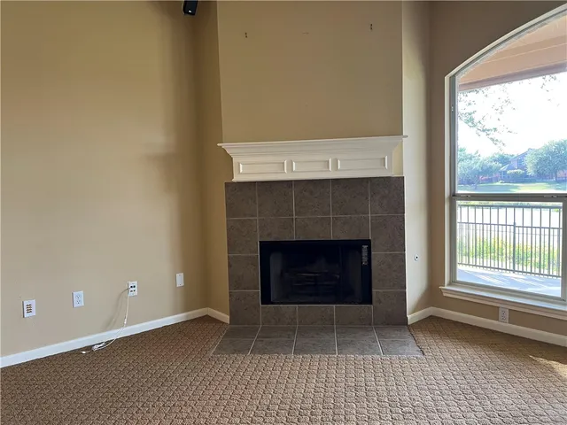 a living room with a fireplace and a floor to ceiling window