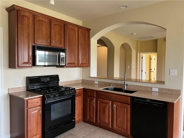 a kitchen with stainless steel appliances granite countertop a stove a sink and a microwave