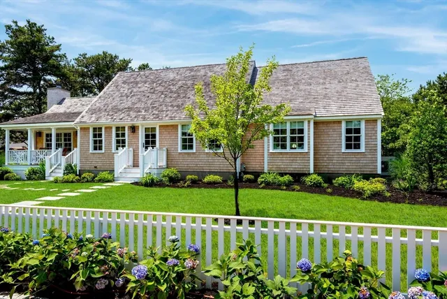 a view of a house with a big yard and potted plants