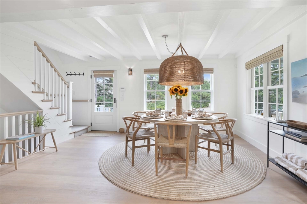 37 Rd To The Plaines Edgartown, MA 02539 - Photo 12 of 42 a dining room with wooden floor a chandelier a wooden table and chairs