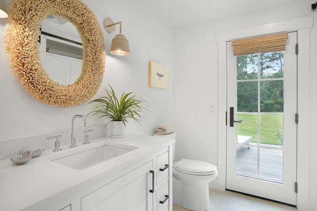 a bathroom with a toilet sink vanity and mirror