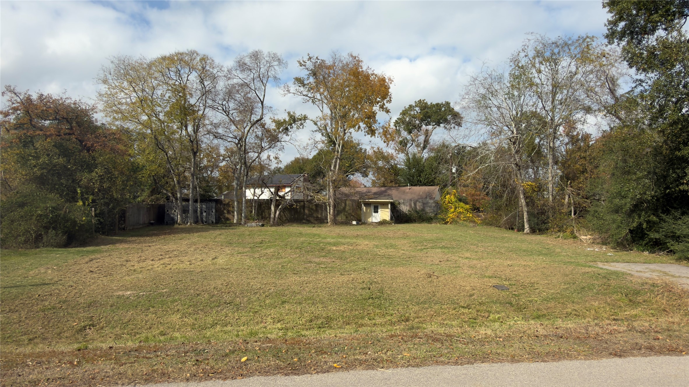 a tall yellow house with trees in front of it
