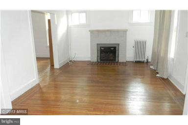 227 Mallow Hill Road Baltimore, MD 21229 - Photo 4 of 11 a view of empty room with wooden floor and fireplace